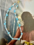 A beaded necklace with light blue and white beads, including star-shaped beads.